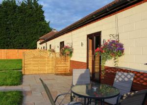 a patio with a table and chairs and a building at Beech Tree Lakes Lodges in Hatfield