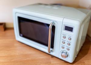 a white microwave oven sitting on top of a table at Beech Tree Lakes Lodges in Hatfield