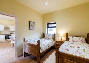 sypialnia z 2 łóżkami pojedynczymi i kuchnią w obiekcie Beech Tree Lakes Lodges w mieście Hatfield