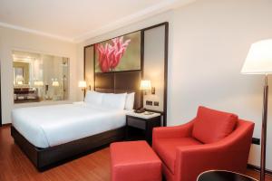 a hotel room with a bed and a red chair at Hilton Garden Inn Lima Surco in Lima