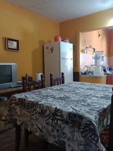 een keuken met een tafel en een koelkast bij Il Giardino de Santa in Santa Teresita