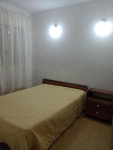 een slaapkamer met een bed en twee lampen aan de muur bij Il Giardino de Santa in Santa Teresita