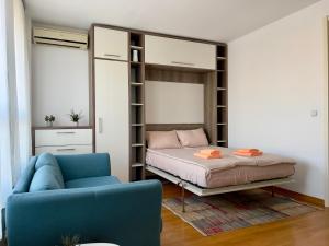 Cozy Apartment SOFI in Belville في Novi Beograd: غرفة نوم مع سرير بطابقين وأريكة زرقاء