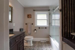 a bathroom with a toilet and a shower and a window at Trail-Ready Retreat near Waterfalls w/ Hot Tub in Brevard +26 photos