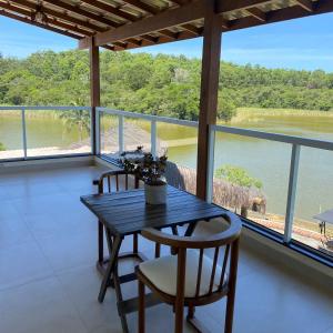 uma sala de jantar com uma mesa e duas cadeiras em Pousada Peninsula Santa Rita em Guarapari