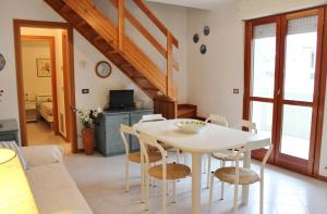 ein Wohnzimmer mit einem weißen Tisch und Stühlen in der Unterkunft Appartamenti Rosanna in Grado