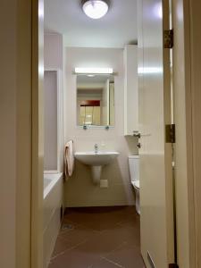 Cozy Apartment SOFI in Belville في Novi Beograd: حمام مع حوض وحوض استحمام ومرحاض
