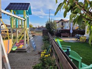 un parque infantil con un tobogán en un patio en Jardin Maison - Therme- self access, en Baloteşti