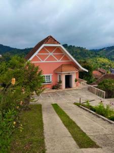 una casa rosa con un camino que conduce a ella en Cantinho nascer do sol, en Campos do Jordão
