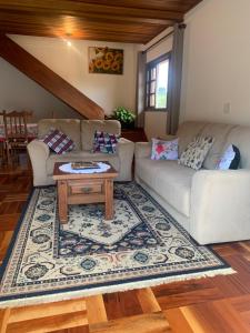 uma sala de estar com um sofá e uma mesa de centro em Cantinho nascer do sol em Campos do Jordão