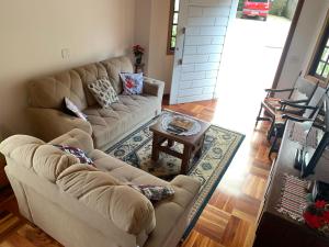 a living room with two couches and a coffee table at Cantinho nascer do sol in Campos do Jordão