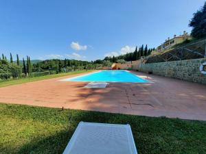 ein großer Pool in einem Hof mit einer Steinmauer in der Unterkunft 3-Bed Duplex Apartment in Vepri close to Siena in Bucine