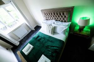 a bed in a room with a green wall at Pristine Relocation 3-Bed House in London in London