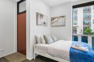 1 dormitorio con cama y ventana grande en Urban Thrive Studio is in a great location en Auckland