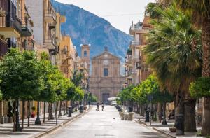 pusta ulica miejska z kościołem i palmami w obiekcie Casa del mare Mely w mieście Ficarazzi