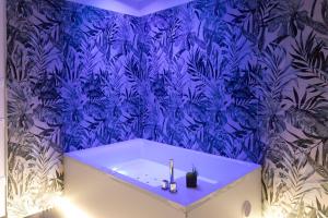 a blue bathroom with a tub with a blue wallpaper at Luxury 144 B&B in Crotone