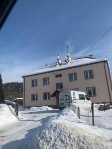 a building with a van parked in the snow at Ropienka ski micro in Wańkowa