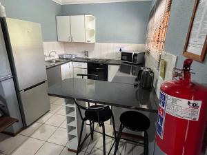 a kitchen with a refrigerator and a fire hydrant at Pendleberry Grove Unit 51 in Bela-Bela
