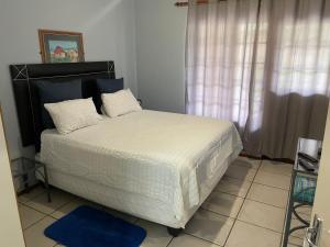 a bedroom with a large bed with white sheets at Pendleberry Grove Unit 51 in Bela-Bela