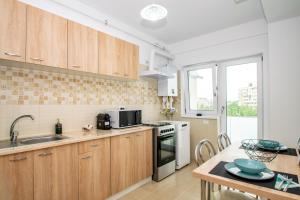 a kitchen with wooden cabinets and a table at Apartament Central in Craiova