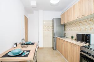 a kitchen with wooden cabinets and a counter top at Apartament Central in Craiova +7 photos