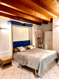 Schlafzimmer mit einem großen Bett mit blauem Kopfteil in der Unterkunft Alloggi Mincio in Goito