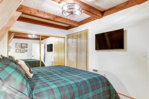 1 dormitorio con 1 cama y TV de pantalla plana en Pet-Friendly Arnold Cabin with Deck and EV Charger!, en Arnold
