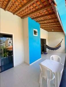 Habitación con mesa, sillas y pared azul. en summer house, en Praia Grande