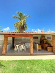 una casa con un patio con una palmera en summer house, en Praia Grande