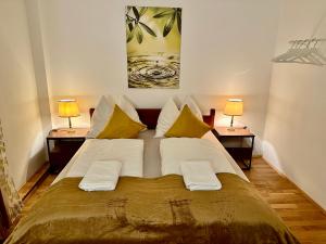 a large bed in a room with two lamps at The Peaceful Garden Family Stay with Free Parking in Salzburg