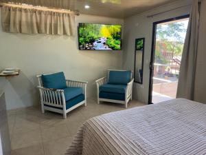 a bedroom with two chairs and a tv on the wall at Apartamento Villa in Villarreal