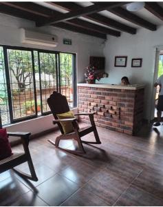 a living room with a rocking chair and a fireplace at Hotel La Casona Vieja in Valledupar