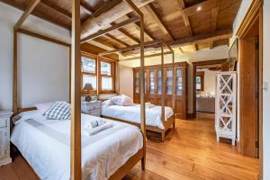 拉科魯尼亞的住宿－Fee4Me La Casita de Oza，卧室设有2张床和木制天花板。