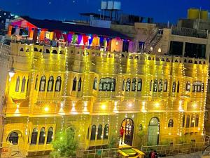 un edificio giallo con luci accese di notte di Hotel Tokyo Palace a Jaisalmer