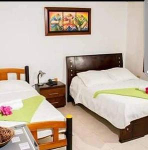 1 dormitorio con 2 camas individuales y mesa con mesa en Hotel La Casona Vieja, en Valledupar