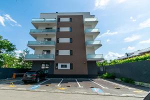 a building with a car parked in a parking lot at Apartament Central in Craiova