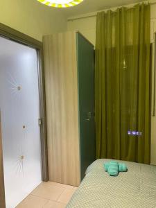 1 dormitorio con 1 cama y cortina verde en Kennedy Apartment, en Quattromiglio
