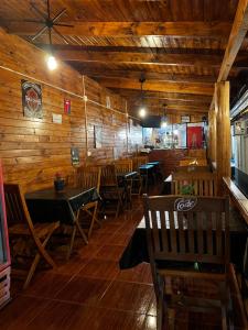 a dining room with wooden walls and tables and chairs at Nature Iguazu hostel B&B in Puerto Iguazú