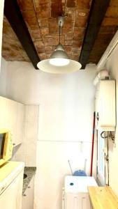 uma cozinha com uma luz pendurada no tecto em Cozy Ploblesec Apartment em Barcelona