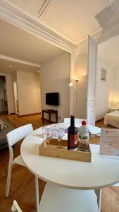 a table with two glasses and a bottle of wine at Cozy Ploblesec Apartment in Barcelona