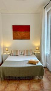a bedroom with a bed with two lamps and a painting at Cozy Ploblesec Apartment in Barcelona
