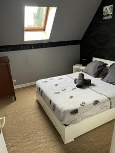 1 dormitorio con cama blanca y cabecero negro en Gîte du Domaine de La Reine Blanche, en Criquetot-sur-Longueville