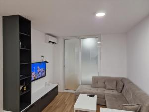 - un salon avec un canapé et une télévision dans l'établissement Apartment 4th. Floor II, à Banja Luka