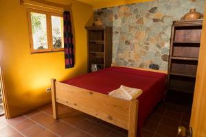 a bedroom with a bed with a red bedspread at Casa Maria Vista, Espectacular View in Santa Cruz La Laguna