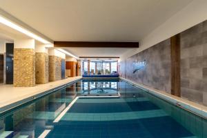 una piscina con azulejos azules en el vestíbulo del hotel en Art Hotel superior en Zalakaros