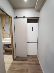 - une cuisine équipée d'un réfrigérateur blanc dans l'établissement Le Cocon Design - Gare / Centre ville de Caen, à Caen