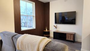 - un salon avec un canapé et une télévision dans l'établissement Bridge Street Apartments, à Peterborough