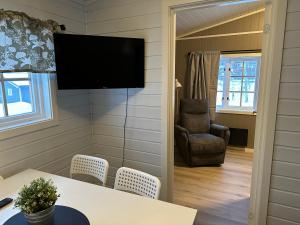 a living room with a television on the wall at Langnes Camping, Grong in Grong