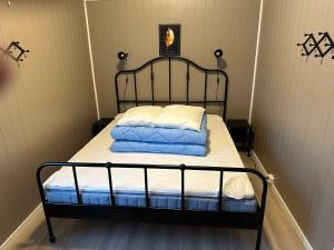 a bed with a black frame and white sheets and pillows at Langnes Camping, Grong in Grong