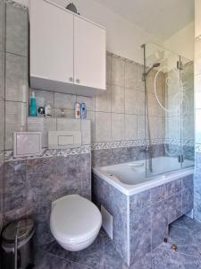 uma casa de banho com um WC e uma banheira em Apartmani Skejic em Split